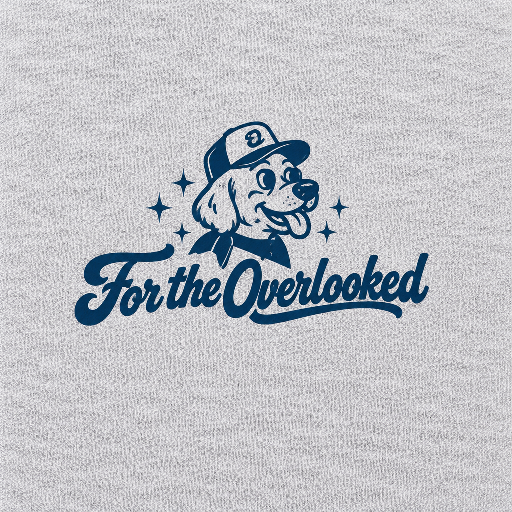 Close-up of the navy dog and For the Overlooked chest logo on the light gray Overlooked Club T-shirt